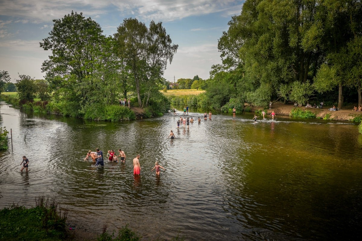 A photo of a thermometer showing high temperatures, with a blurred background of a UK city, the primary keyword 'UK heatwave' is used to describe the scene