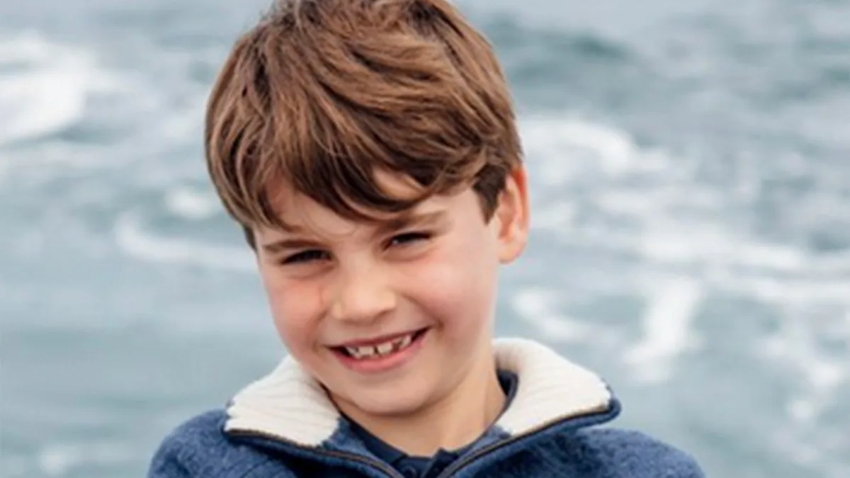 Prince Louis smiling and waving on a boat trip, surrounded by family, with a beautiful blue sea and clear sky in the background, enjoying his 8th birthday celebration with a fun outdoor adventure