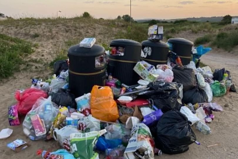 A deserted Wales beach littered with rubbish and debris, with a few seagulls flying overhead, highlighting the devastating impact of pollution on our environment, with the primary keyword 'Wales beach' featured prominently