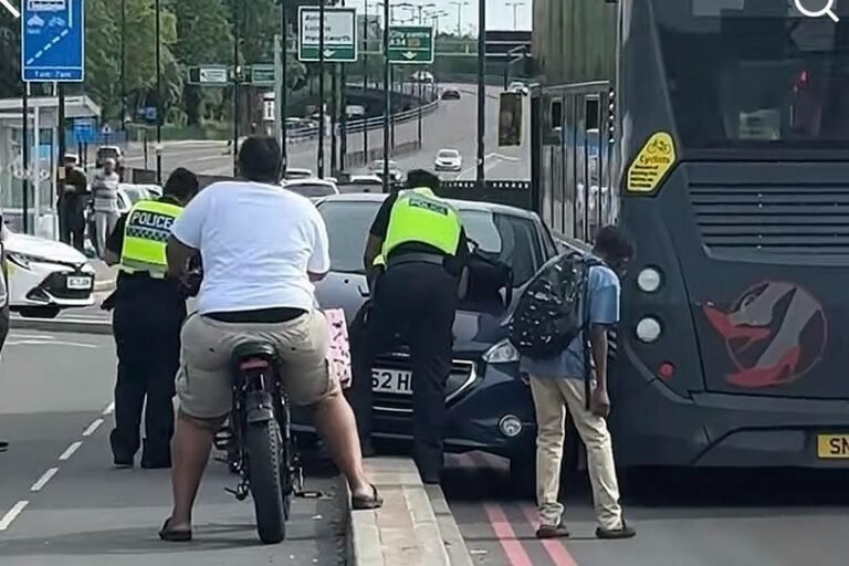 A car stuck facing the wrong way beside a bus on a busy Birmingham route, with people gathered around, looking concerned and amused, highlighting the importance of road safety and cautious driving, with the primary keyword being Birmingham bus route