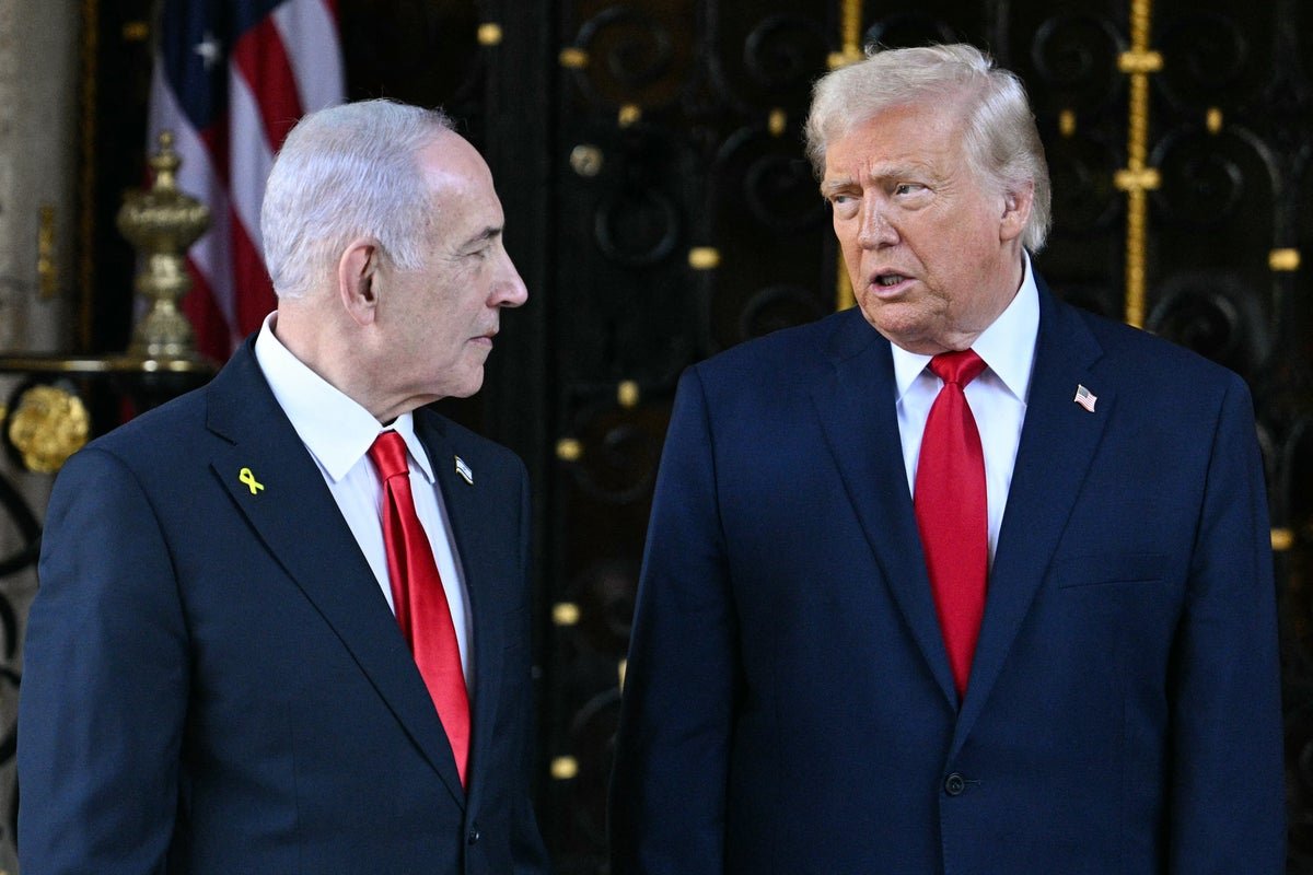 US President Donald Trump and Israeli Prime Minister Benjamin Netanyahu shake hands during a meeting, with a backdrop of the Israeli and US flags, symbolising the complex and sensitive nature of their diplomatic relationship