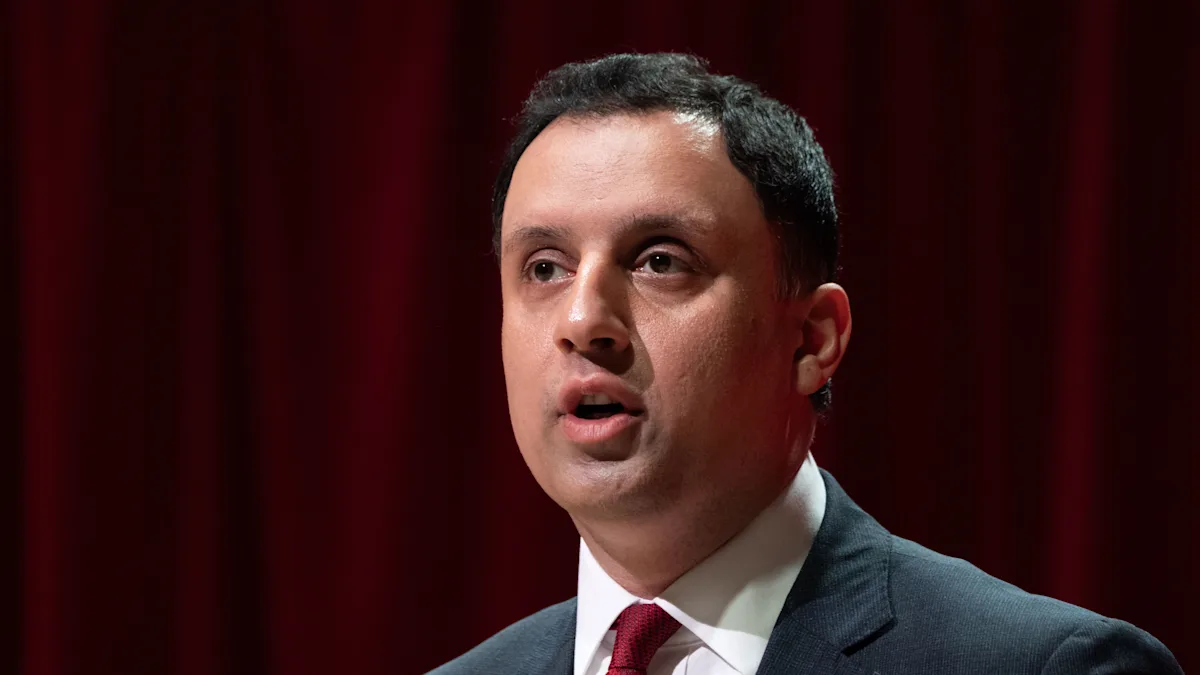 Anas Sarwar, leader of the Scottish Labour Party, campaigning for Reform in the upcoming election, with a crowd of supporters in the background, waving flags and banners, as they prepare for the big day, with a focus on creating a better future for Scotland