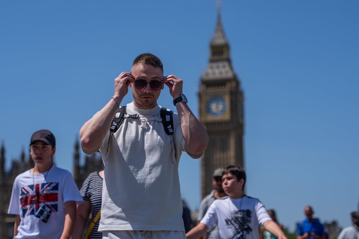A sunny day in London with people enjoying the warm weather in a park, with a description of the primary keyword heatwave