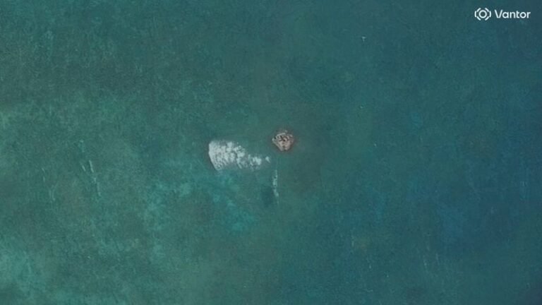 A satellite image of the South China Sea, showing a suspected structure at a disputed atoll, with the colour of the water and the movement of ships clearly visible, highlighting the primary keyword of South China Sea