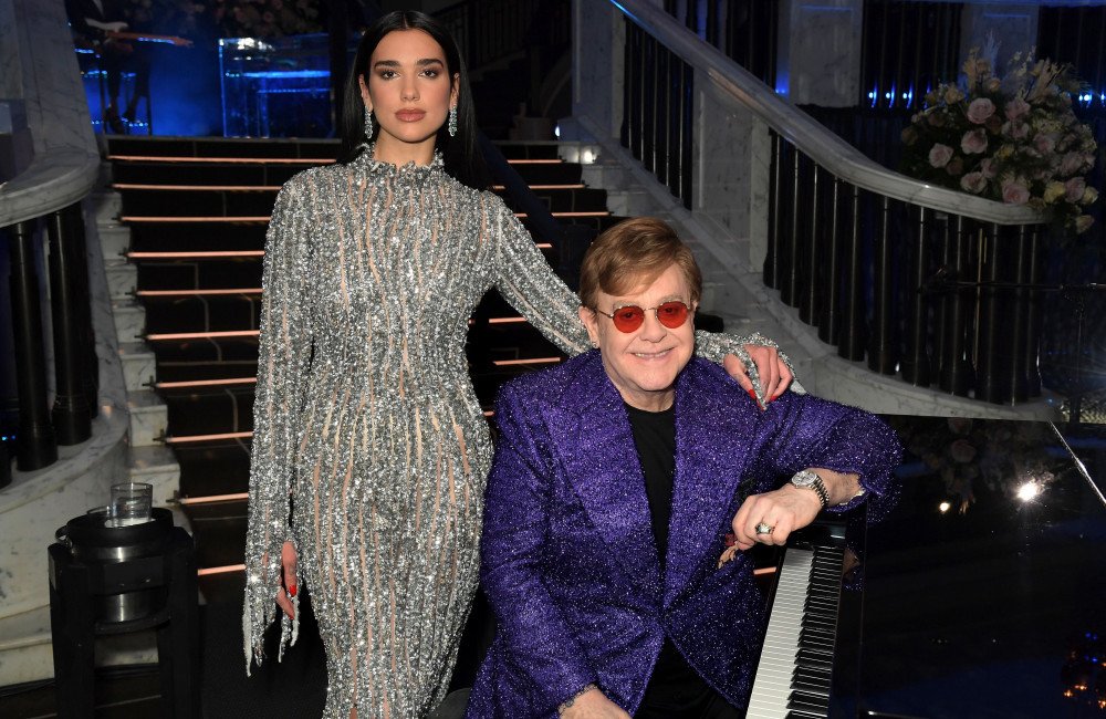 Dua Lipa and Callum Turner share a romantic kiss on their wedding day, surrounded by loved ones and with Sir Elton John in attendance, a truly unforgettable occasion with a touch of magic