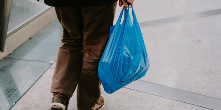 A person holding a plastic bag with a confused expression, surrounded by recycling bins and symbols, highlighting the importance of proper plastic bag recycling and waste management