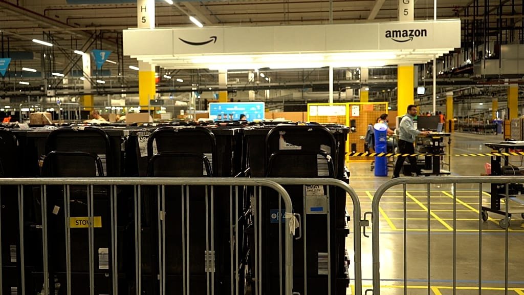 A descriptive image of Amazon's busiest European warehouse, showcasing robots and humans working together in a state-of-the-art facility, highlighting the company's commitment to innovation and customer satisfaction, with a focus on the primary keyword phrase 'Amazon warehouse'