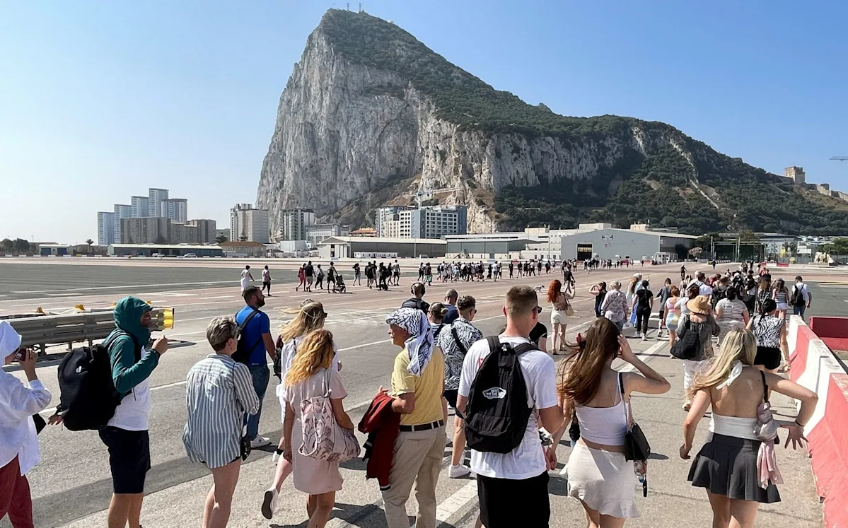 A descriptive image of the Gibraltar border crossing, with a fingerprint scanner in the foreground, highlighting the EU's new fingerprint entry scheme and its impact on Brexit negotiations