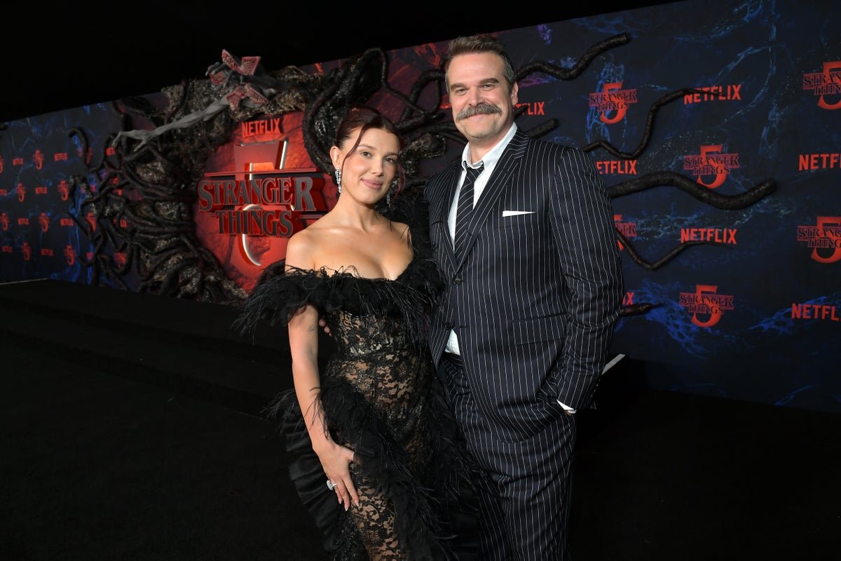 David Harbour and Millie Bobby Brown attend a Stranger Things event, with a crowd of fans in the background, highlighting the show's massive popularity and the importance of the cast's behaviour in the public eye