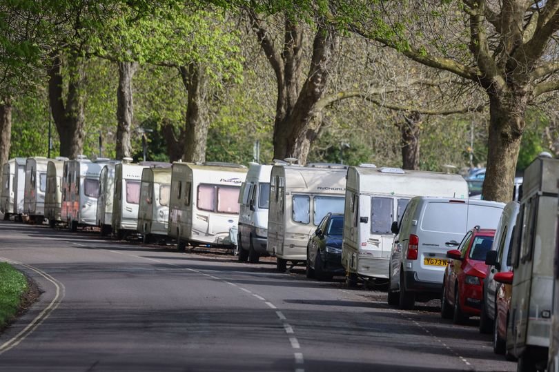 A scenic view of the Downs with vans parked in the distance, highlighting the beauty of the area and the presence of van dwellers, with a focus on the UK van dwelling community