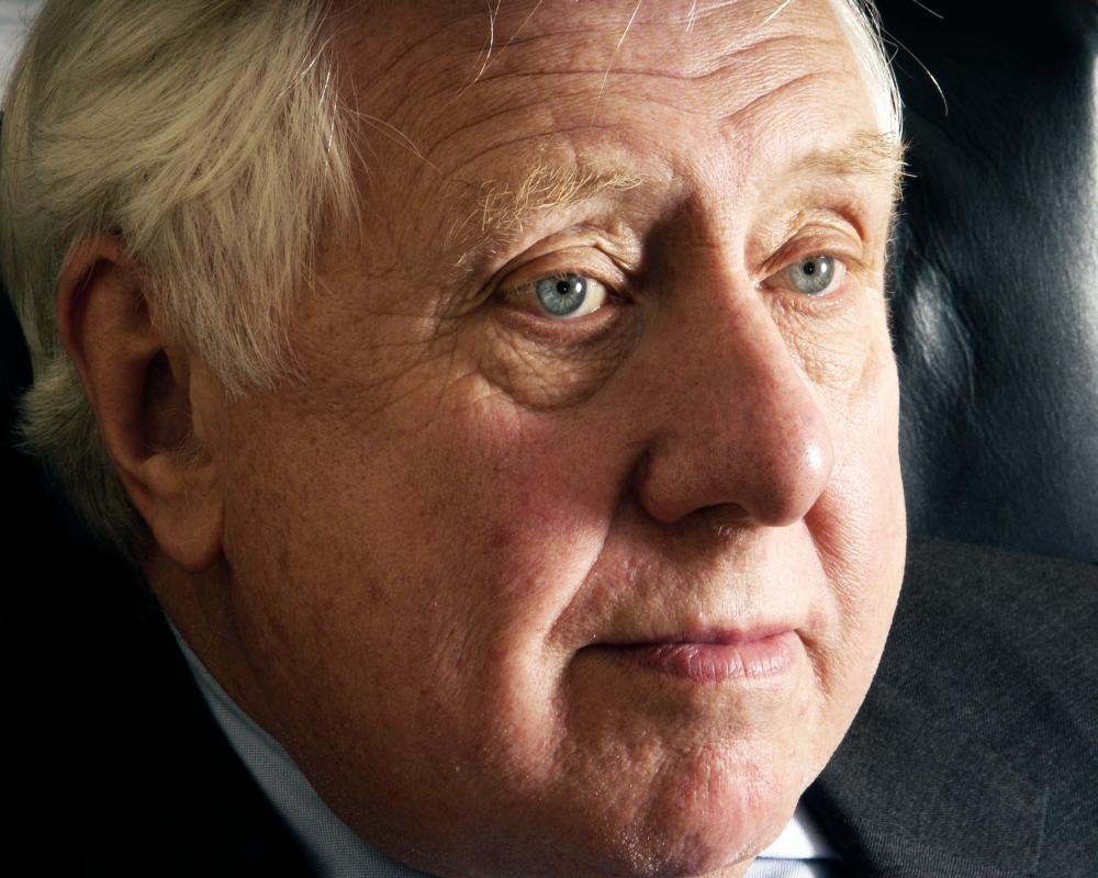 Portrait of Roy Hattersley, former Labour deputy leader, with a descriptive caption highlighting his contributions to the Labour movement and British politics, including his commitment to social justice and his role in shaping the Labour party's policy agenda
