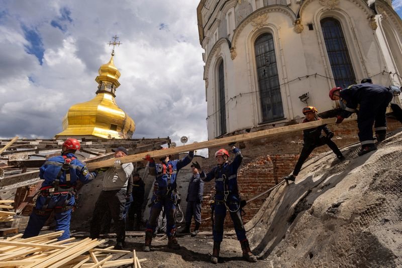 A damaged monastery in Kyiv, Ukraine, with a cracked wall and shattered windows, undergoing restoration to preserve its historic charm and character, a symbol of the country's rich cultural heritage and resilience