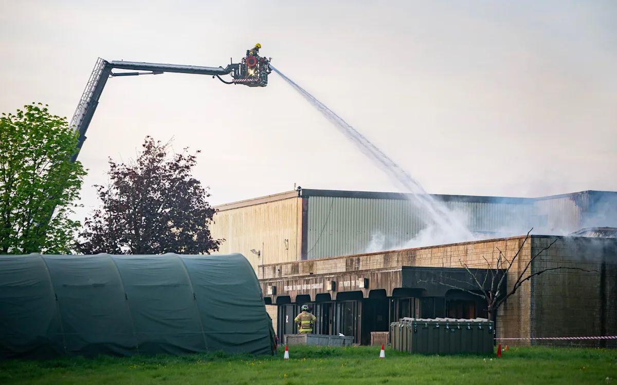 Aerial view of RAF Fairford with smoke billowing from a major fire, as emergency services respond to the incident, highlighting the importance of effective emergency planning and response strategies in Gloucestershire, England