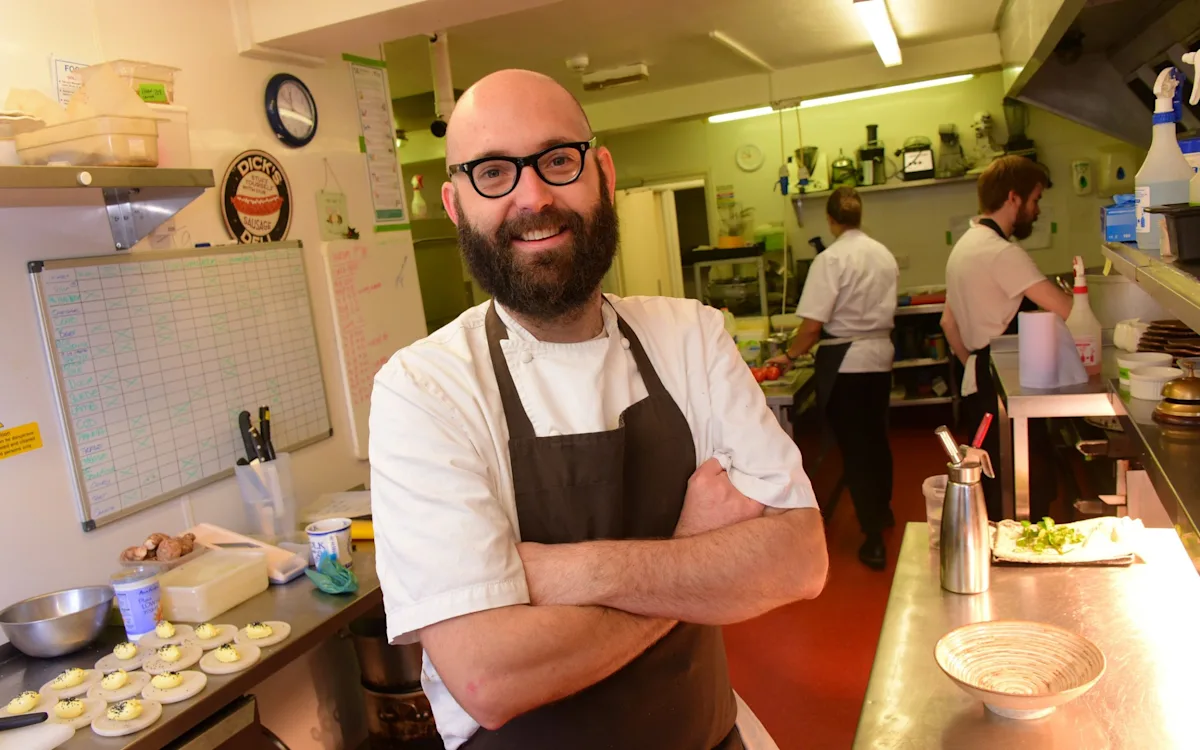 A bottle of house wine on a restaurant table, with a blurred background of people dining, highlighting the importance of wine in the dining experience, with the primary keyword house wine