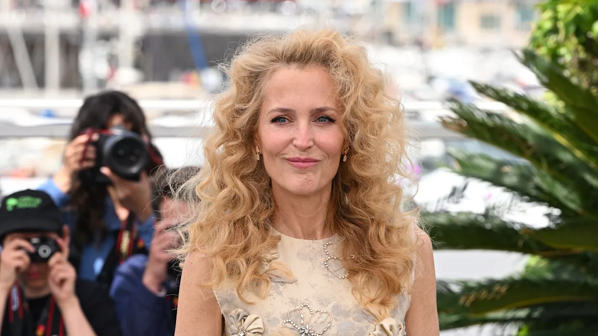 Gillian Anderson walks the red carpet at the Cannes Film Festival, showcasing her stunning 80s-style curls and elegant behaviour, with a beautiful colour dress that complements her hair perfectly, as she analyses the fashion trends and inspires her fans with her unique style