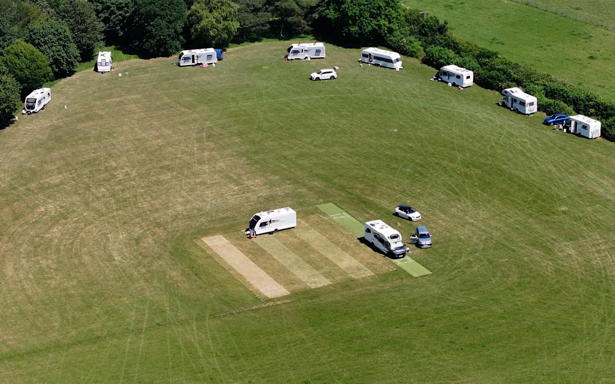 Travellers have taken over a local cricket field, setting up camp with their caravans and vehicles, highlighting the need for more facilities and services to cater to their needs, with the primary keyword being travellers