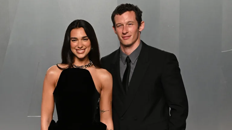 Dua Lipa and Callum Turner share a romantic kiss on their wedding day, surrounded by beautiful flowers and a stunning backdrop, with the primary keyword 'Dua Lipa wedding' describing the scene