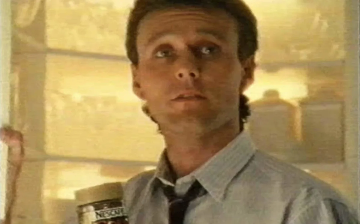 Anthony Head as the Gold Blend man, a charismatic and beloved UK actor, in a classic advert, showcasing his distinctive voice and charming behaviour, with a warm and inviting colour palette, a true icon in UK popular culture