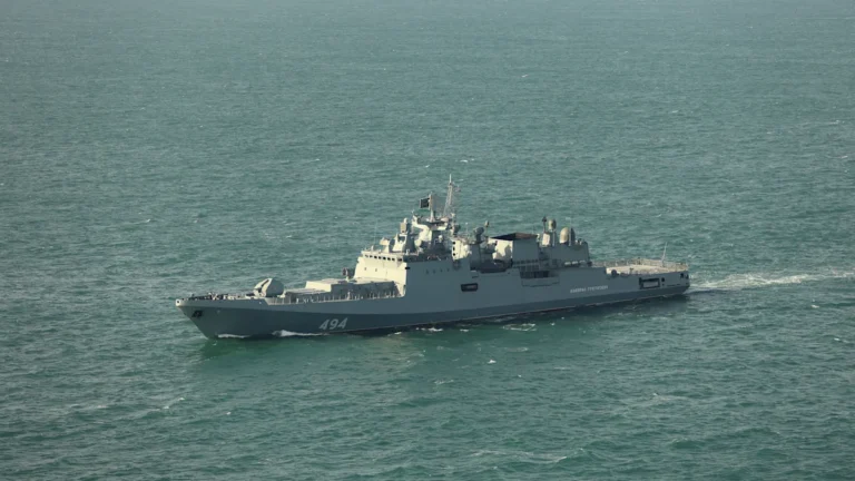 A Russian warship patrols the English Channel, with a vessel in the background, highlighting the importance of maritime safety and international laws, with the primary keyword phrase being Russian warship