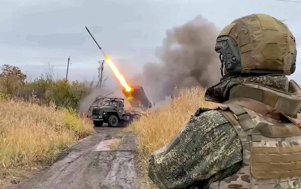 A sombre image of a Russian army soldier, highlighting the primary keyword phrase 'Russian army rampage' and the devastating impact of their actions on innocent civilians, with a focus on the colour and behaviour of the individuals involved